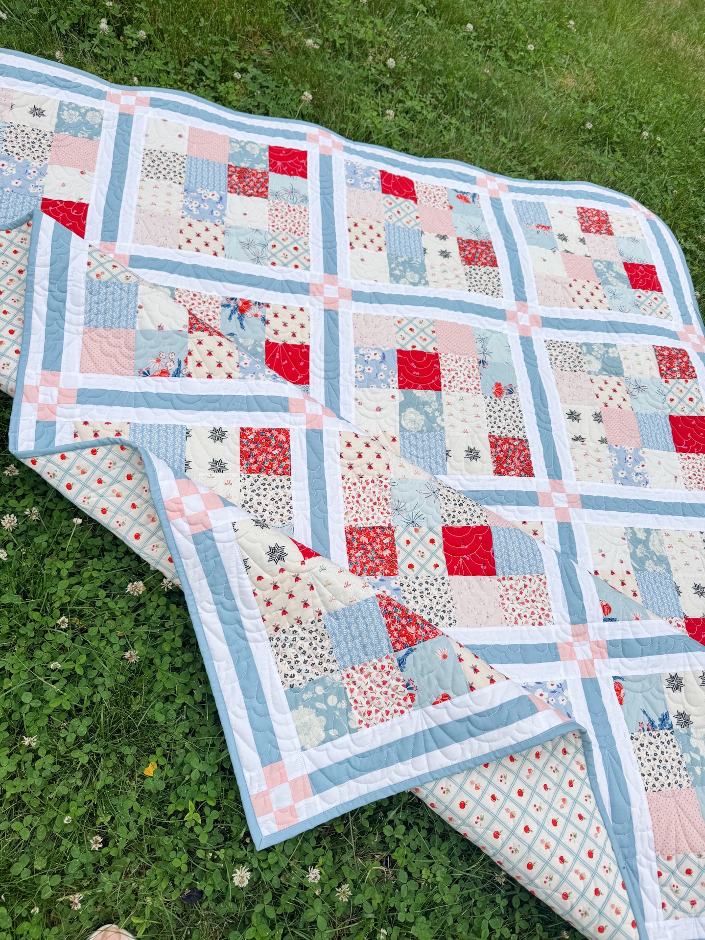 Quilt with a patchwork pattern on a grassy background
