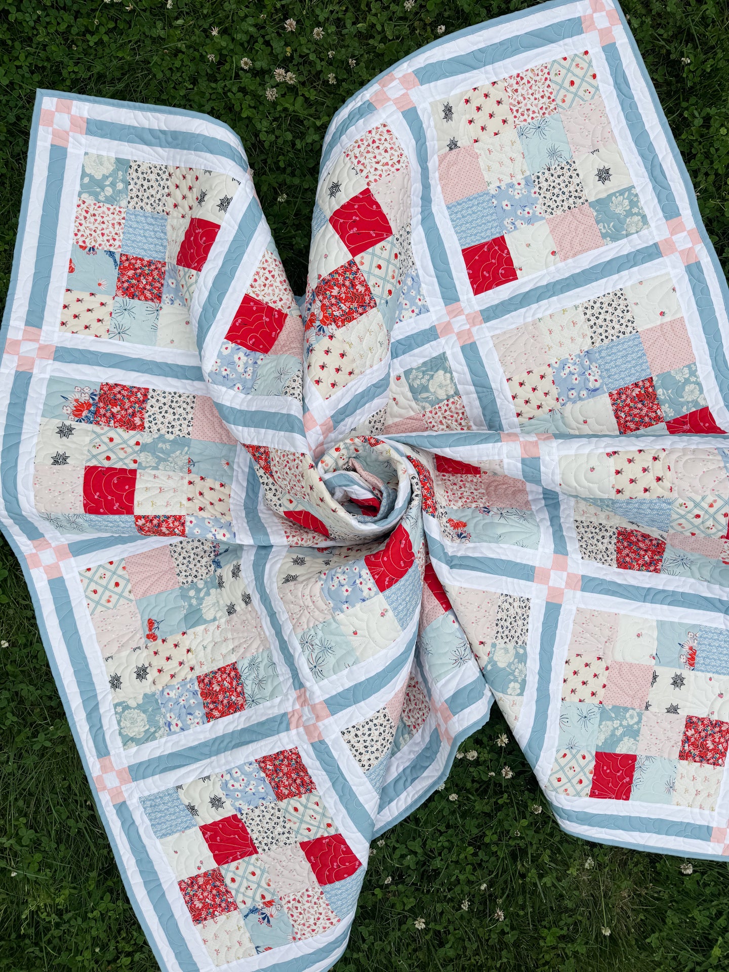 Quilt with patchwork design on a grassy background