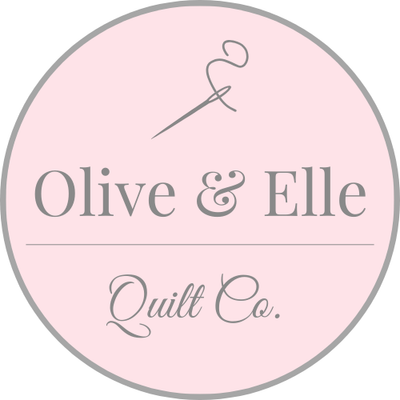 Logo of Olive & Elle Quilt Co. with a pink background and gray text.